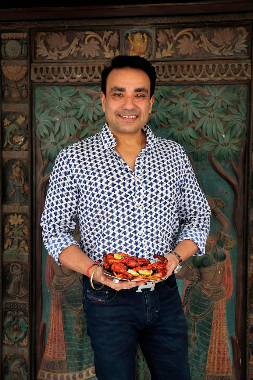 Monish Gujral of Moti Mahal restaurants holds a dish of butter chicken.