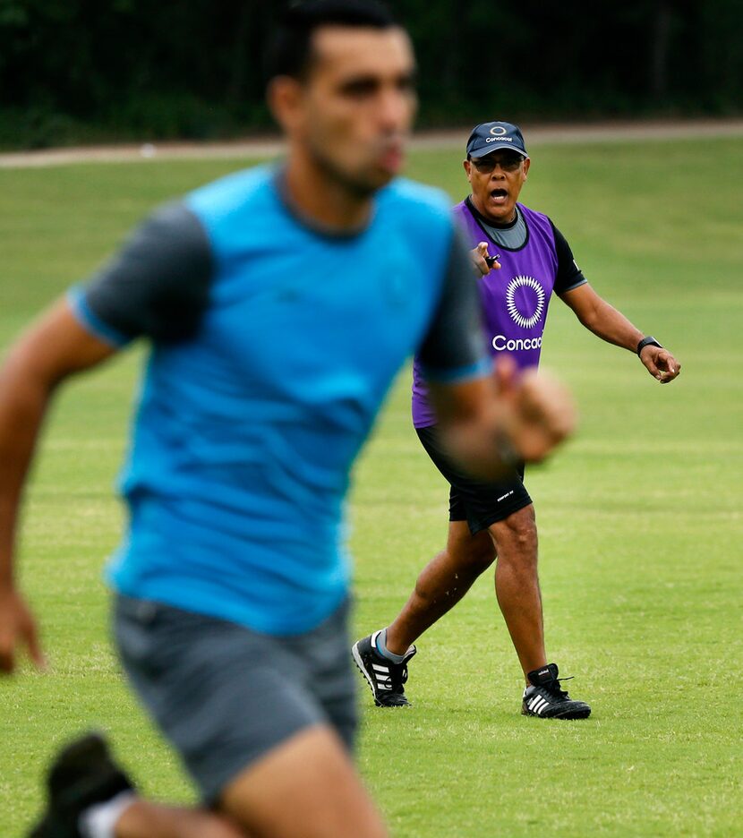 CONCACAF soccer technical instructor Peter Prendergrast (background) yells instruction to a...