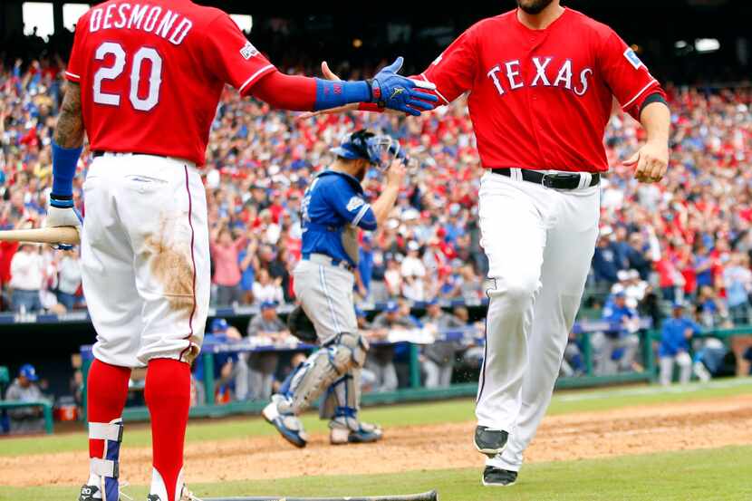 Texas Rangers Mitch Moreland (18) is congratulated on his run by Ian Desmond (20) during the...