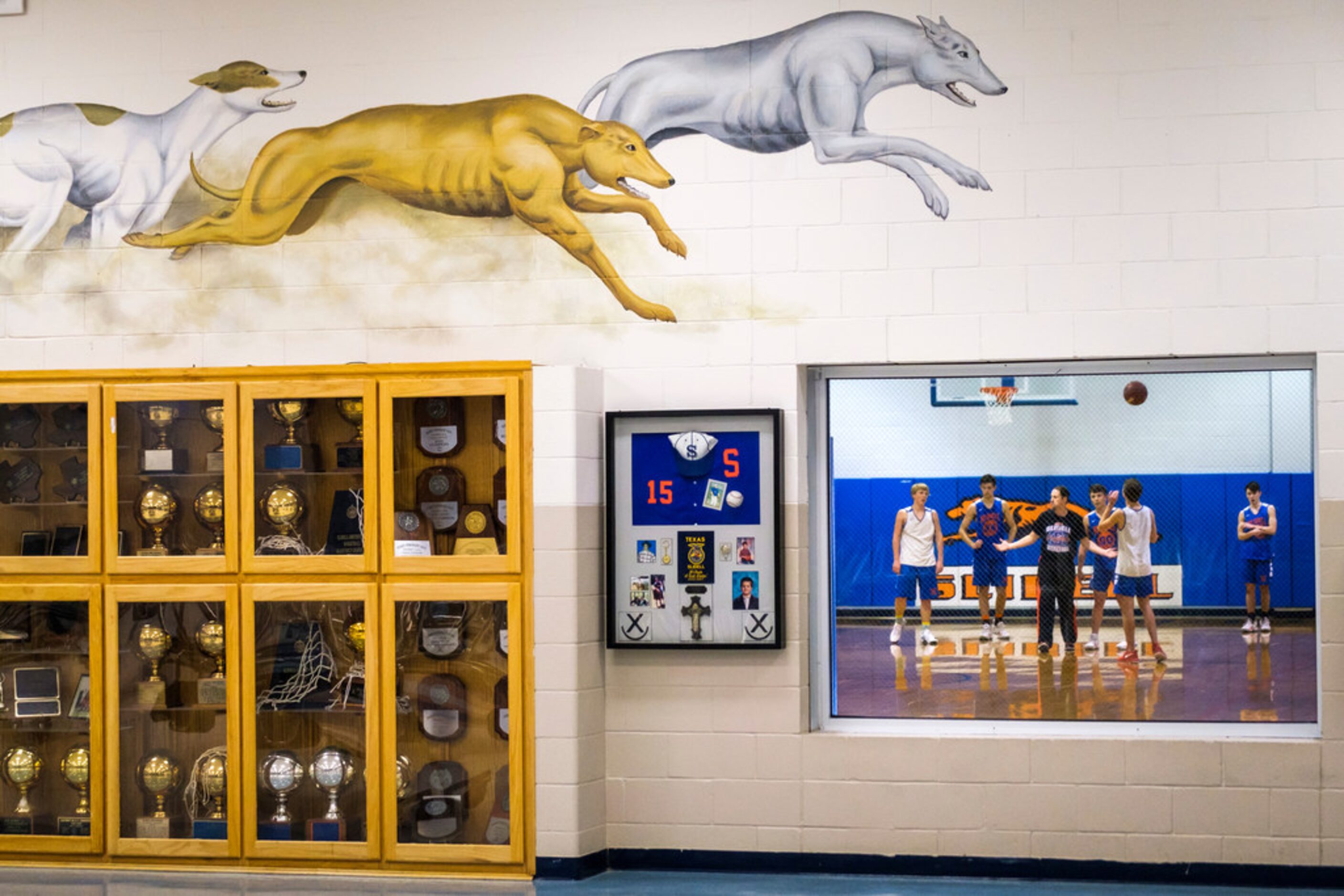 Slidell head coach Casey Pierce is seen through a window leading practice as the school's...