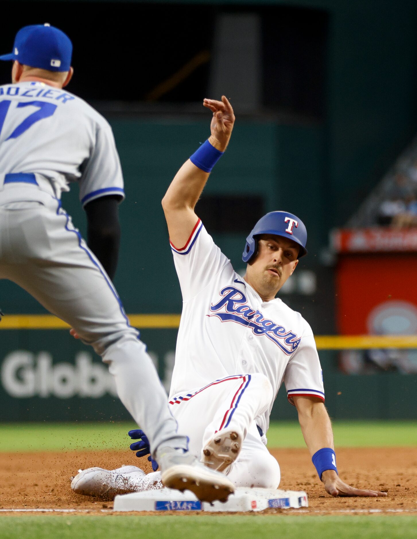 Texas Rangers first baseman Nathaniel Lowe (30) slides safely into third base alongside...