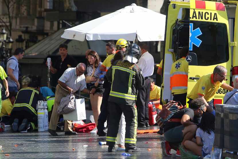 Injured people are treated in Barcelona, Spain, Thursday, Aug. 17, 2017 after a white van...