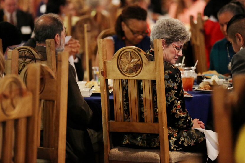 Linda Abramson Evans, of the United Nations Association USA, bows her head as Imam Omar...