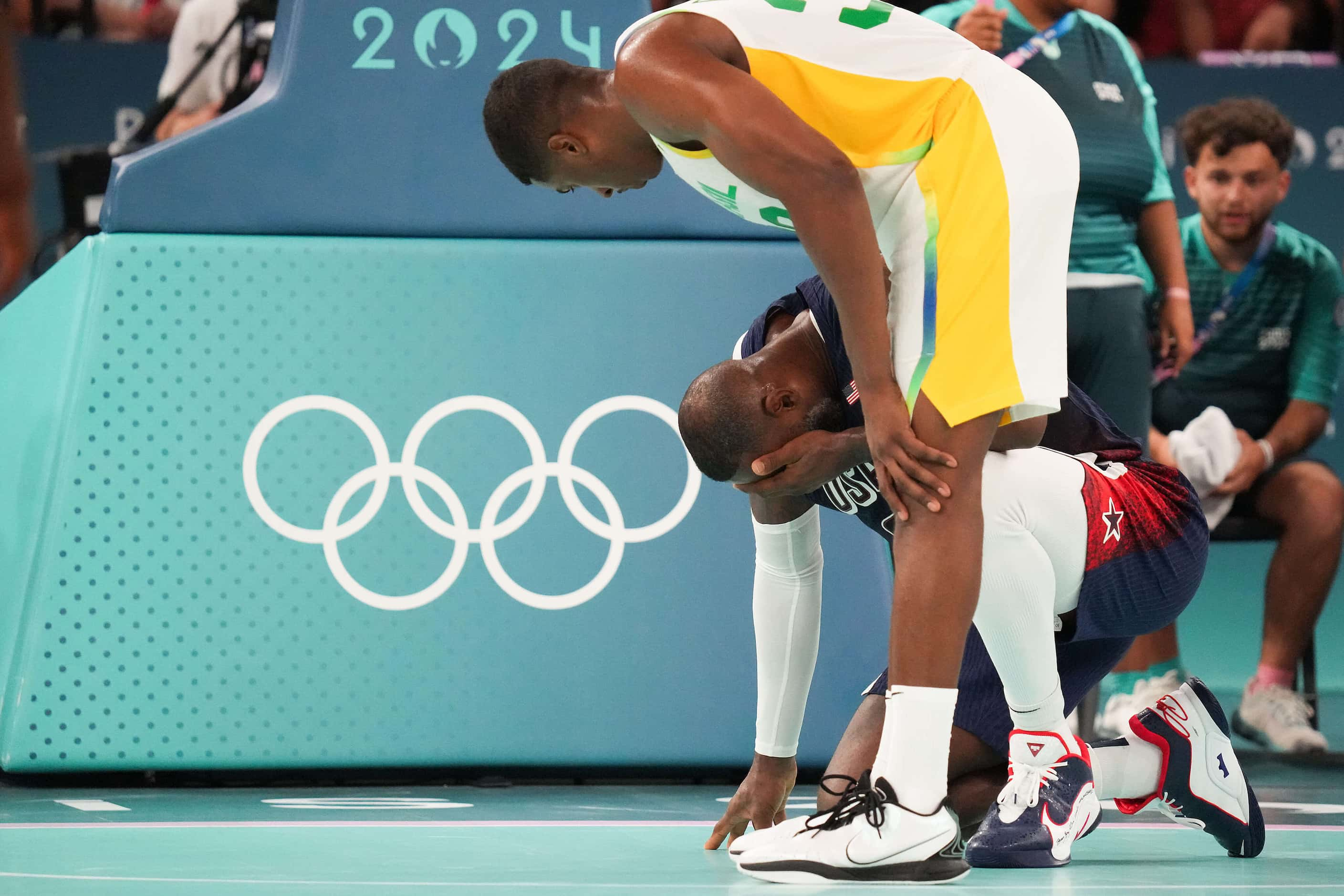 Georginho de Paula (32) of Brazil checks on Lebron James (6) of the United States who was...