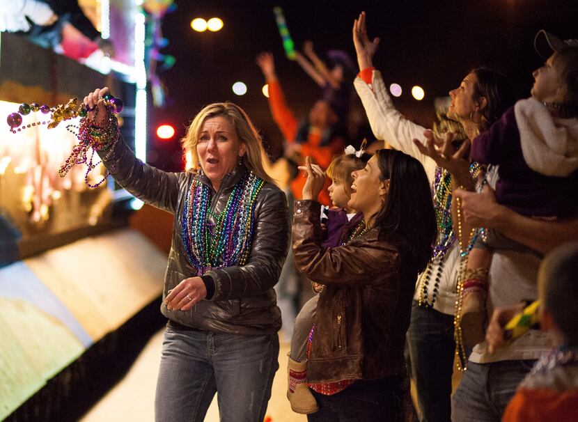 A woman celebrates her bead haul at the Krewe of Centaur parade in Shreveport. 