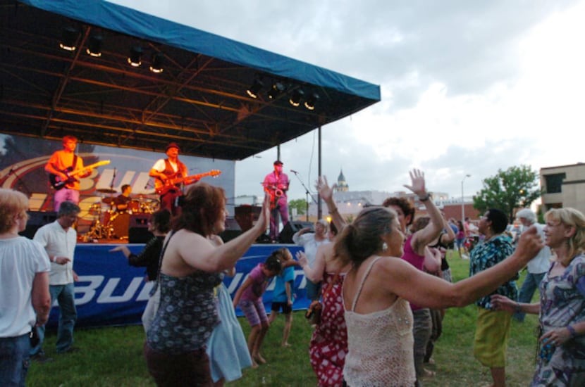 A lively group dances to Denton's own Bubba Hernandez as late afternoon clouds gather over...