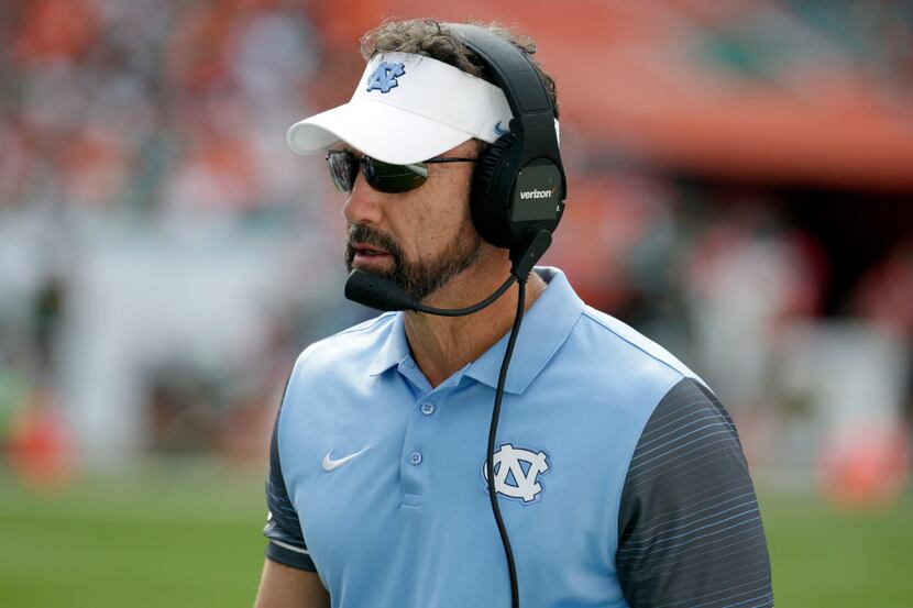 North Carolina head coach Larry Fedora listens on his headset during the first half of an...