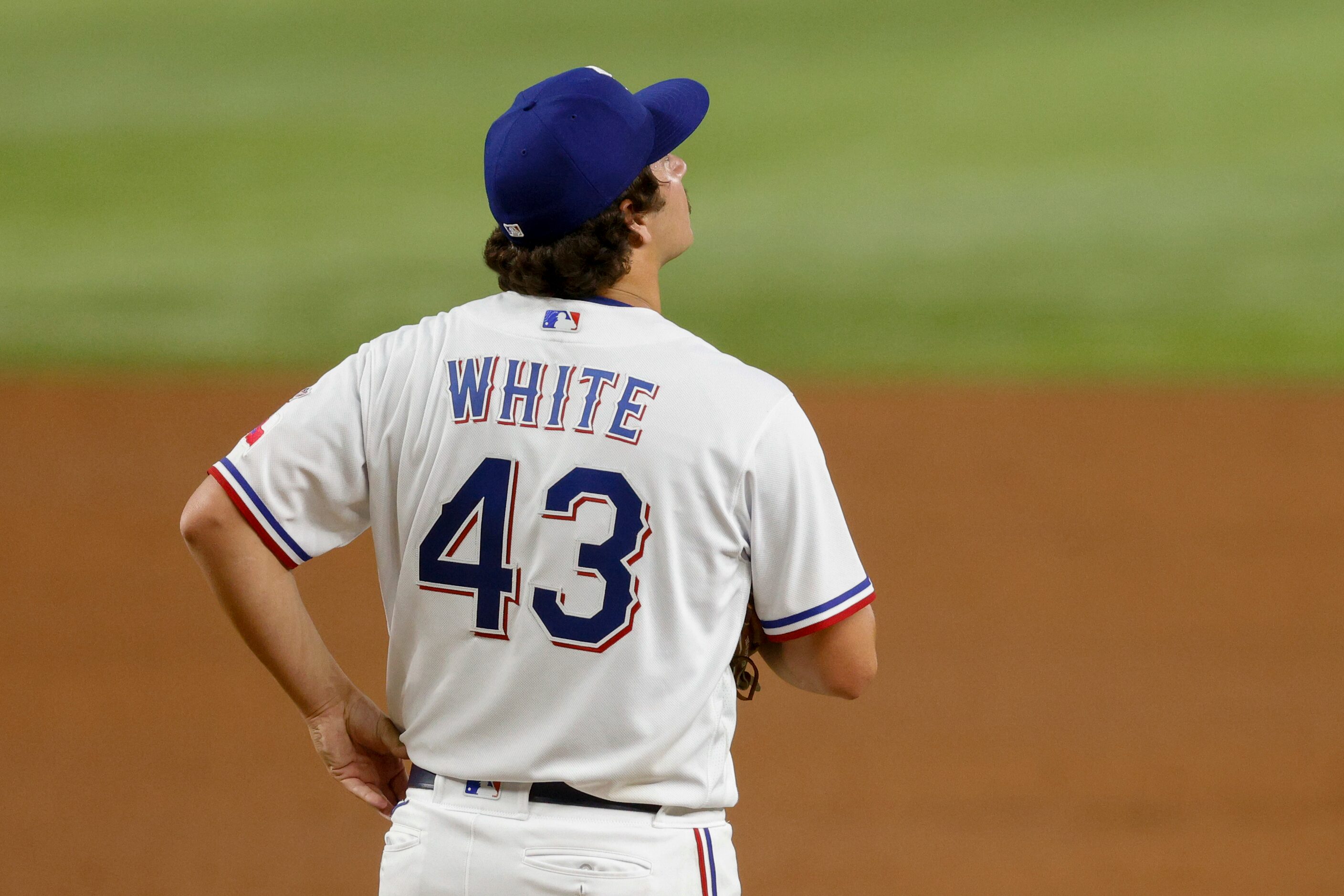 Texas Rangers relief pitcher Owen White (43) watches a replay on the video-board after...