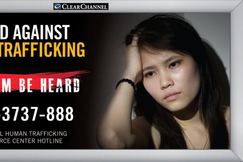 A United Against Human Trafficking billboard shows the phone hotline number for the national...