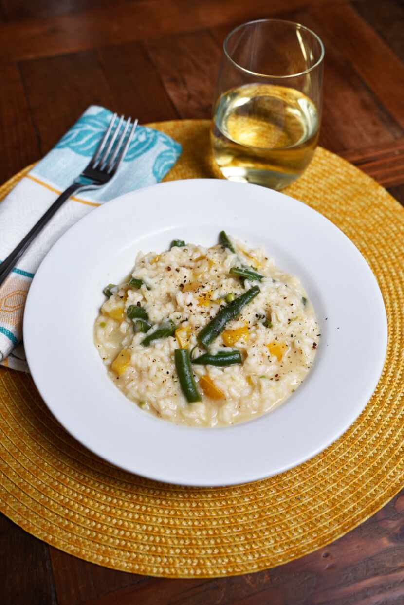 A dish of Marcella Hazan's risotto with green beans and sweet yellow bell peppers served...