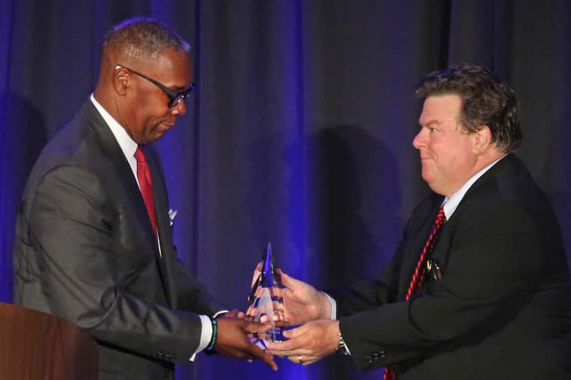 AT&T Chief Compliance Officer David Huntley, left,  accepts an ethics award from Michael...