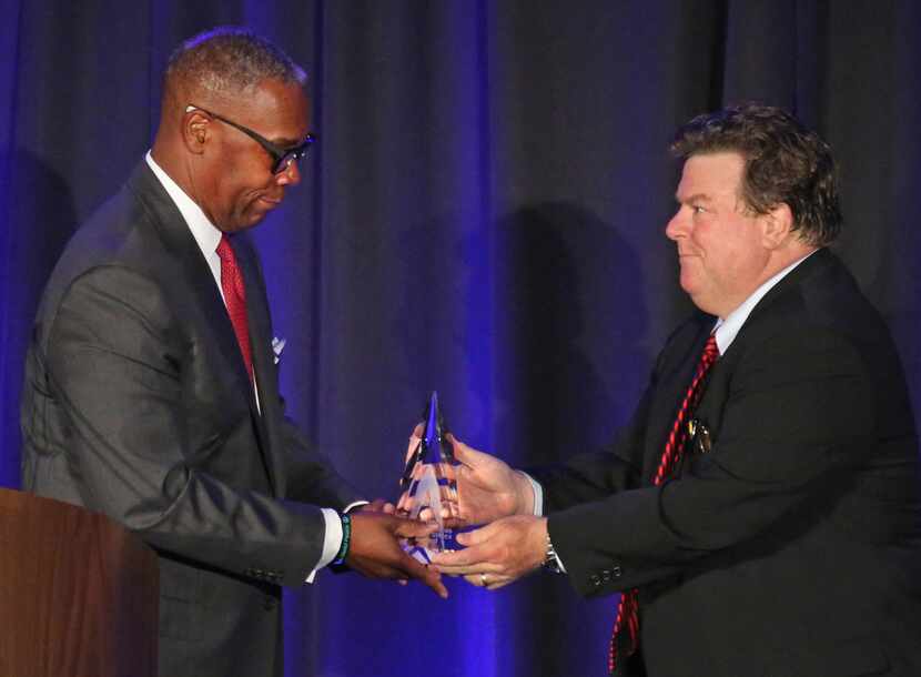 AT&T Chief Compliance Officer David Huntley accepts an ethics award from Michael Webb...
