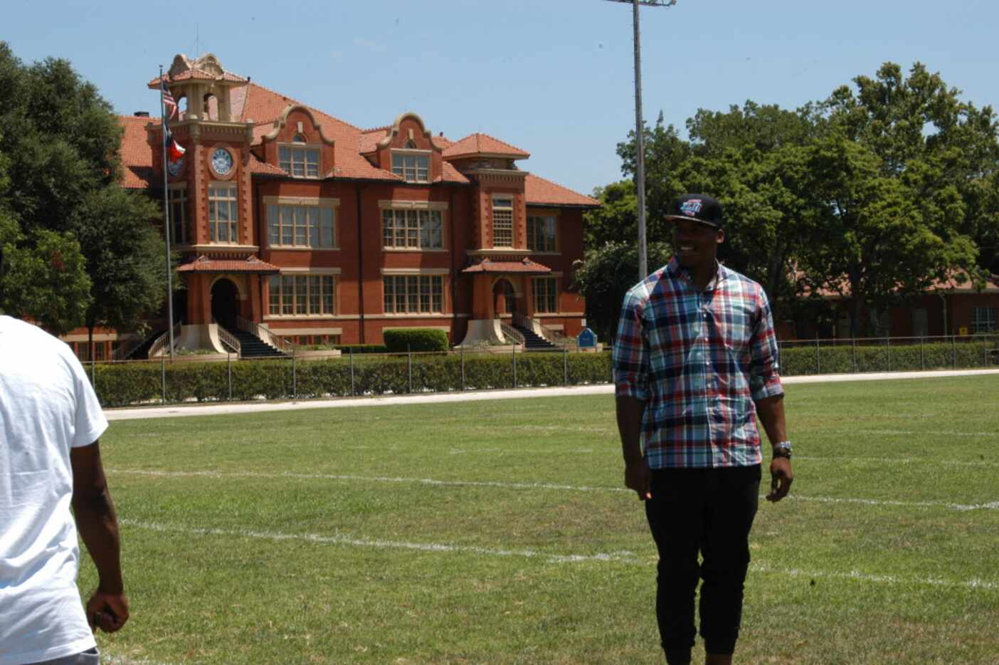 Cam Newton is pictured on the football field at Blinn College with Old Main behind him....