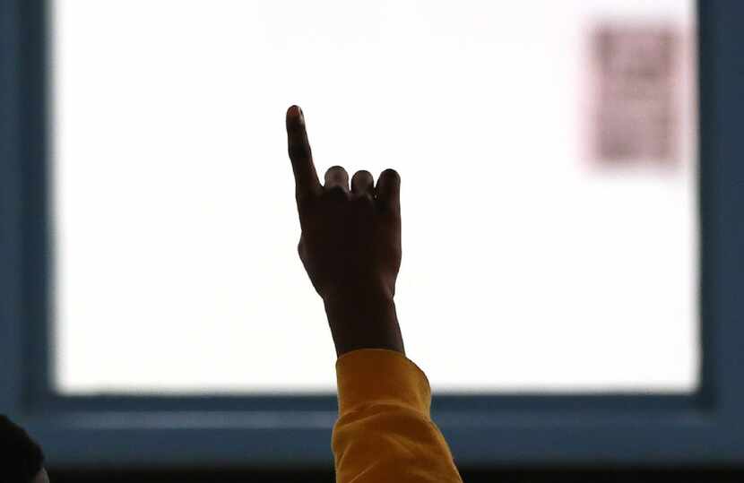 A teen in the STARS program raises his hand to ask a question during a group session at the...