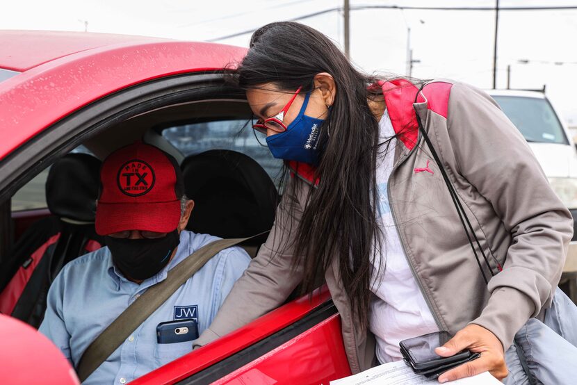 Leslie Armijo helps Jose Cardenas fill out a form at Santa Teresita Catholic Church to...