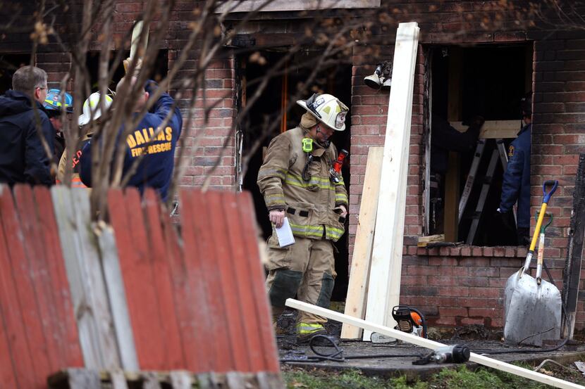 Dallas and Cedar Hill fire-rescue workers reinforce a house that caught fire early this...