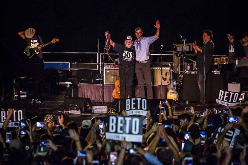 Rep. Beto O'Rourke, D-El Paso, joined by singer Willie Nelson, waves to supporters at a...