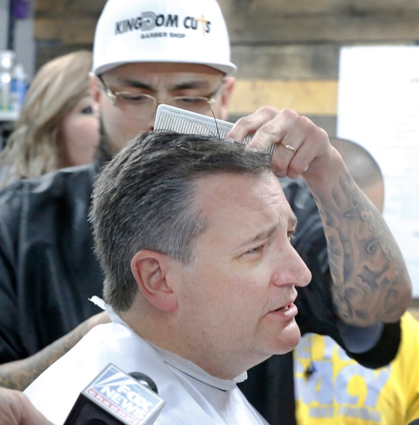 U.S. Sen. Ted Cruz gets a haircut from Adam Rodriguez as he visits Kingdom Cuts Barbershop...