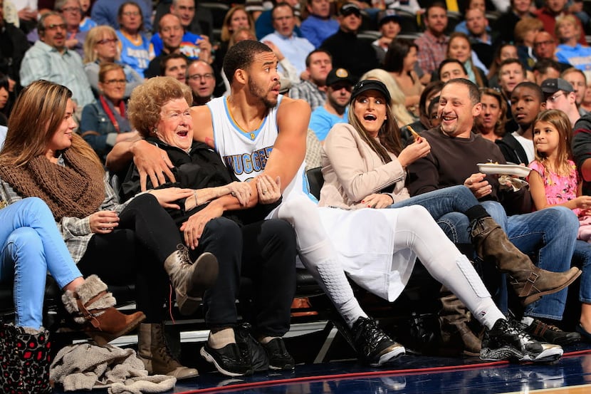 JaVale McGee #34 of the Denver Nuggets protects the fans as he ended up in the front row...