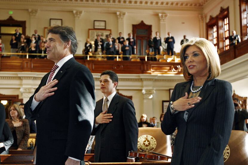 Justice Eva A. Guzman, right, recites the Pledge of Allegiance next to Texas Gov. Rick Perry...