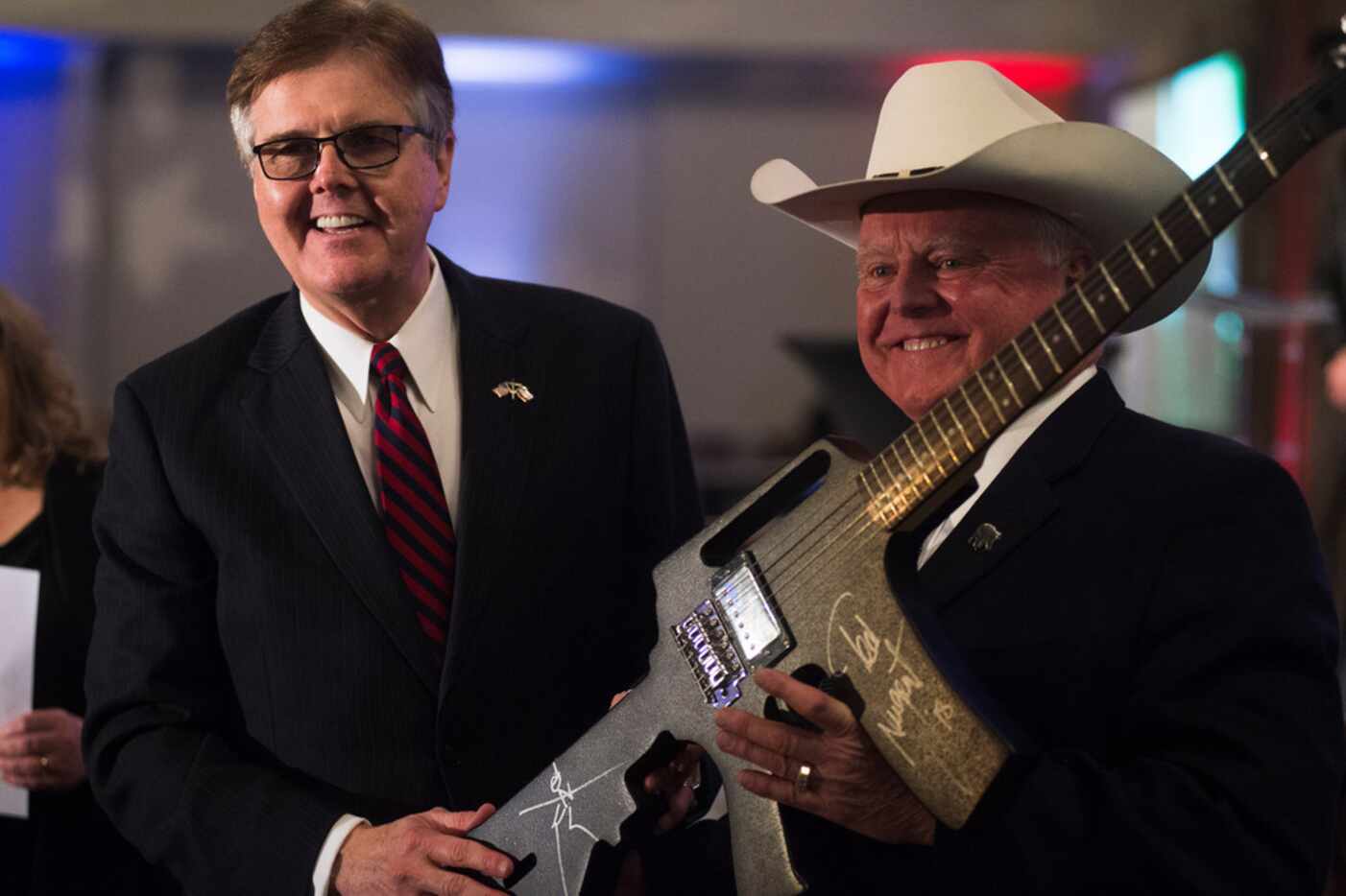 Texas Lt. Gov. Dan Patrick (left) receives a gun-shaped guitar, signed by Ted Nugent, after...