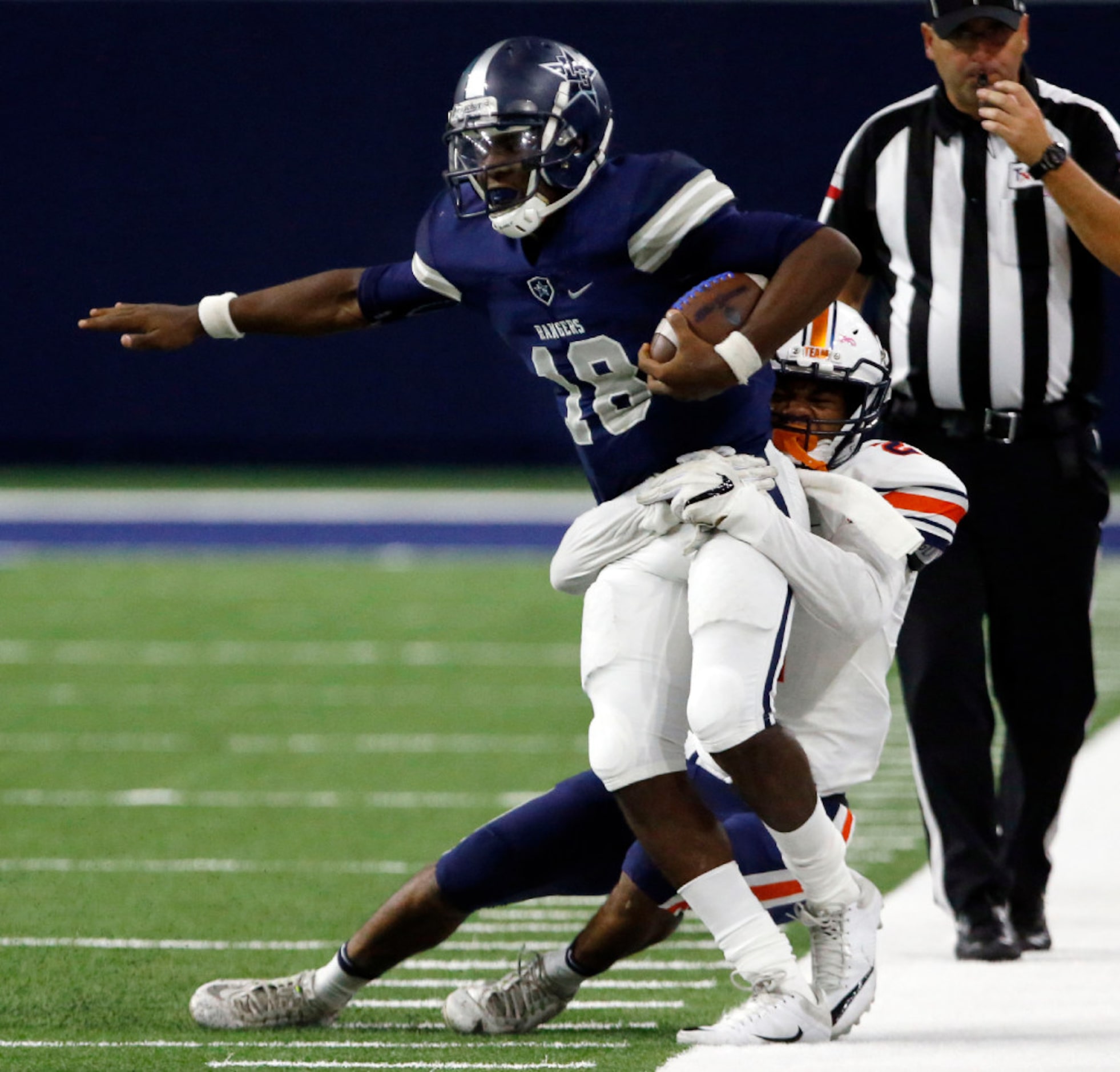 Frisco Lone Star High QB Jason Shelley, (18) is pulled out of bounds by Frisco Lakeland...