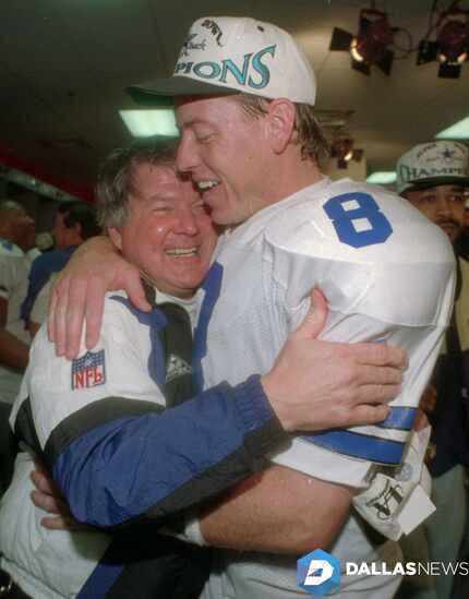 Dallas Cowboys head coach Jimmy Johnson hugs quarterback Troy Aikman in their locker room...