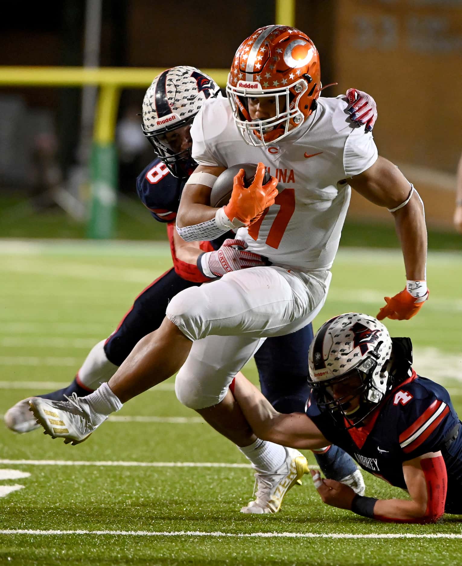 Celina's Gabe Gayton (11) runs through tackle attempts by Aubrey's Jacob Holder (8) and Ty...
