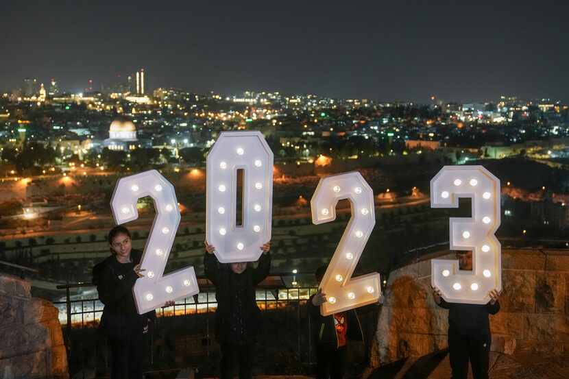 People pose for pictures with a 2023 installation as they celebrate the New Year's eve at...
