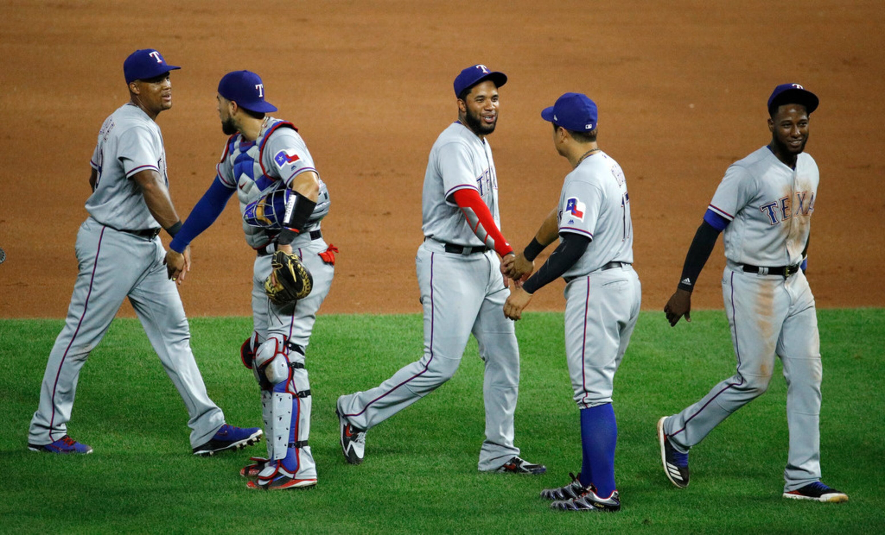 Players for the Texas Rangers celebrate after their baseball game against the Kansas City...