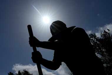 Carlos Rodriguez digs fence post holes Tuesday, June 27, 2023, in Houston. Excessive heat...