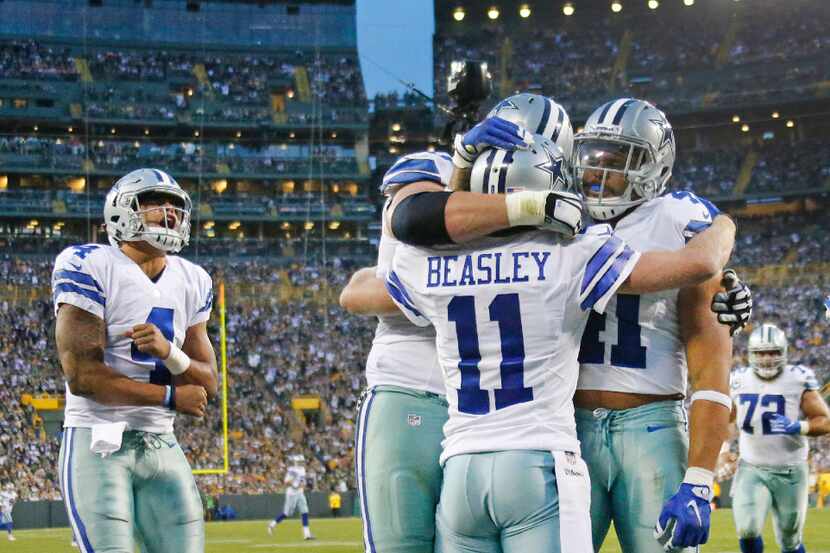 Dallas Cowboys quarterback Dak Prescott (4) leads the cheering as teammates congratulate...
