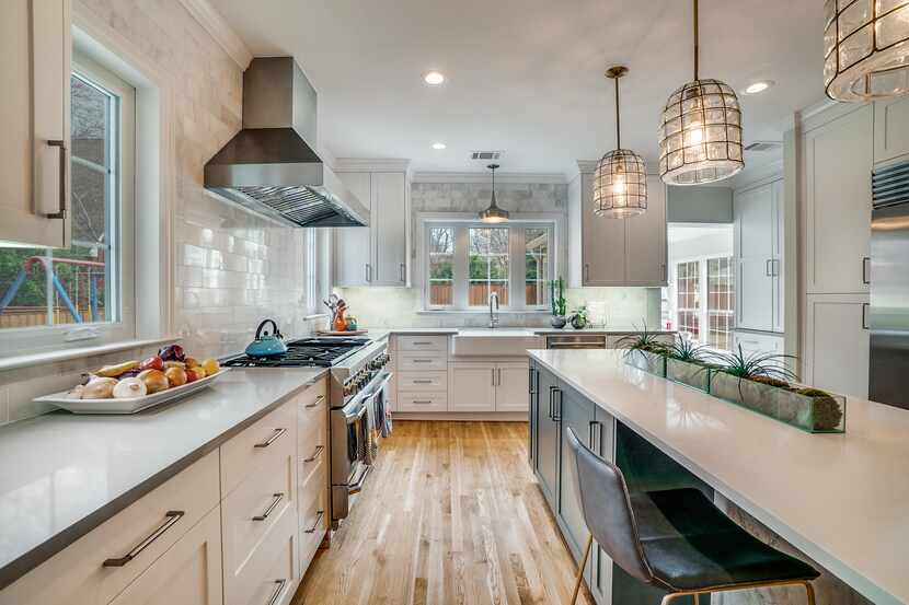 A kitchen is renovated with a large island and wood floors.