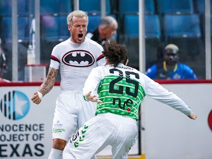 Jamie Lovegrove, wearing a batman shirt, celebrates a goal for the Dallas Sidekicks with #25...