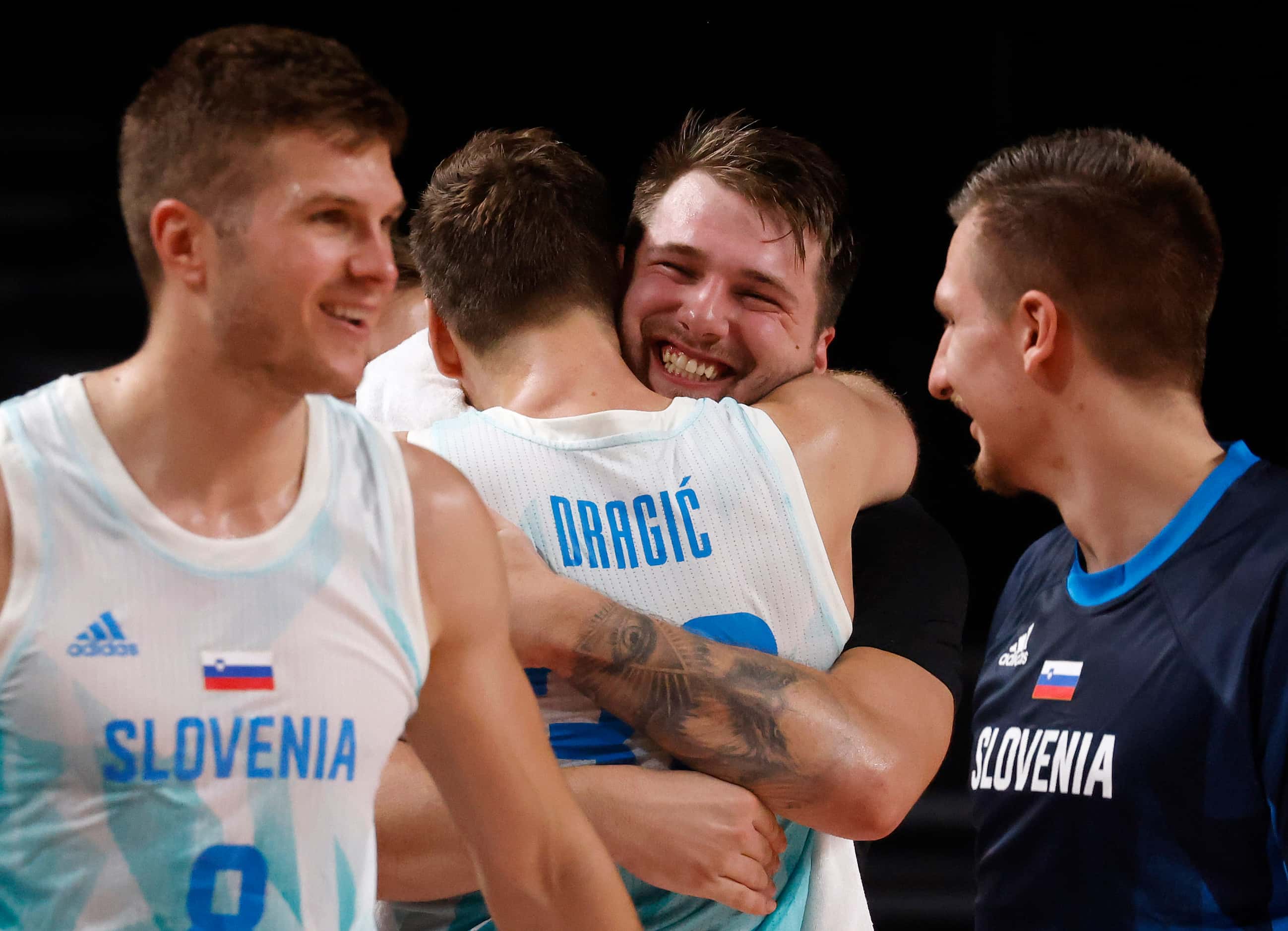 Slovenia’s Luka Doncic (77) hugs Zoran Dragic (30) after both were pulled from play late in...