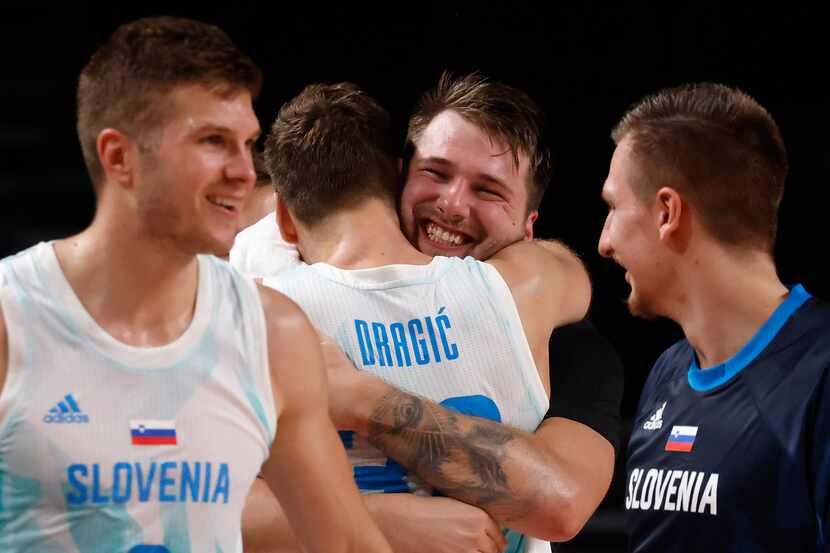 Slovenia’s Luka Doncic (77) hugs Zoran Dragic (30) after both were pulled from play late in...