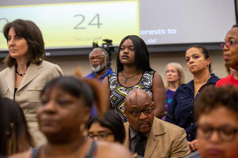 Dallas mother Sematra Brown (center) stands with others to oppose the DISD's move to convert...