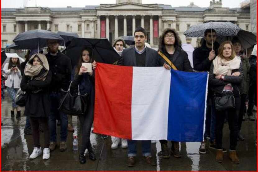 People hold a French national flag in front of the National Gallery in London today to pay...