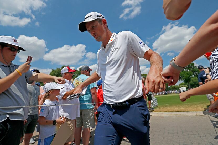 Justin Rose touches hands with fans on the way to the 10th tee box during the final round of...