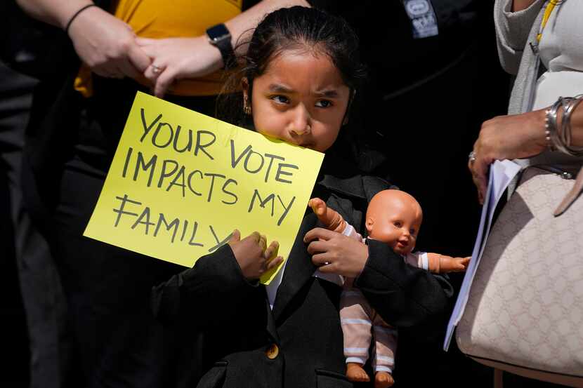 Evelyn Morales, de 6 años, sostiene un letrero durante una conferencia de prensa afuera del...