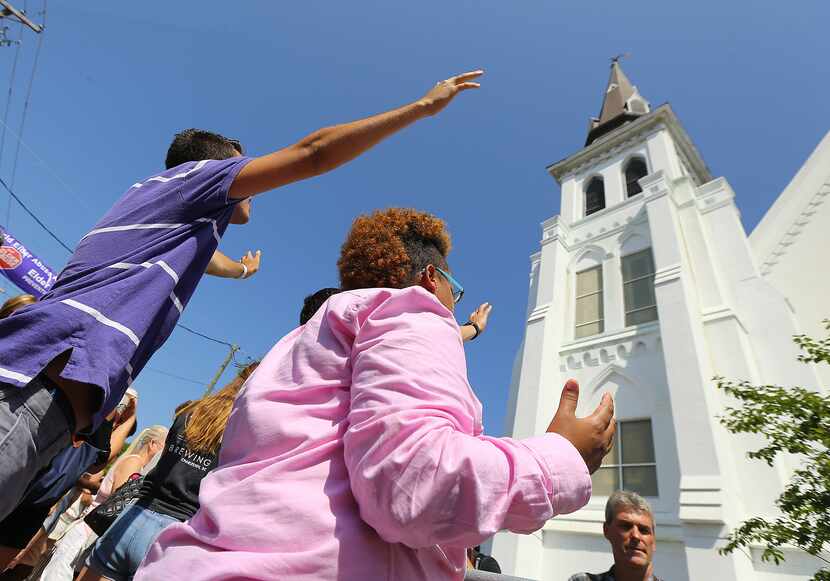 People raise their arms in the air as they listen to the emotional Sunday worship service...