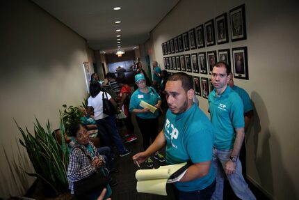 David Villalobos, an organizer for the Texas Organizing Project, waits with HMK tenants...