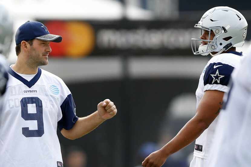 Dallas Cowboys quarterback Tony Romo (9) gives fellow quarterback Dak Prescott (4) a fist...