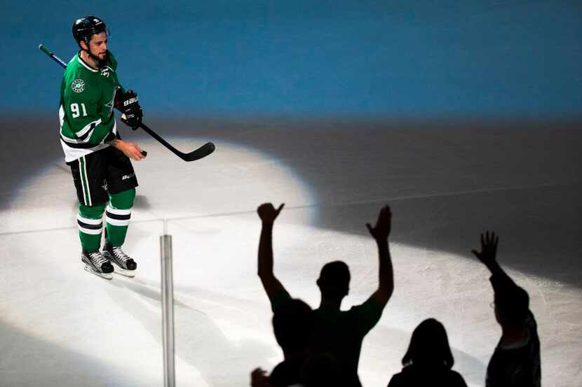 Fans try to get a puck from Dallas Stars center Tyler Seguin after an NHL preseason hockey...