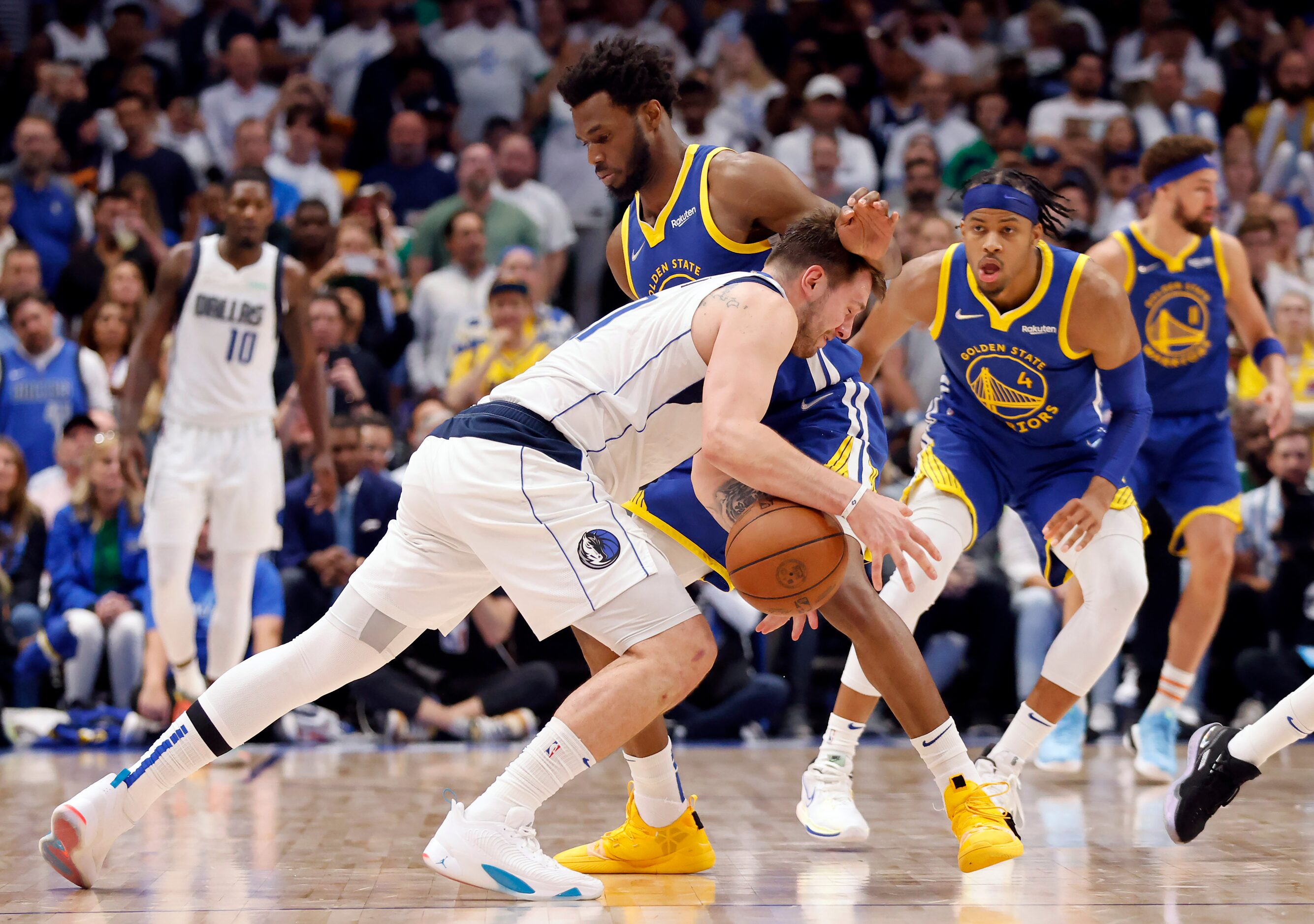 Dallas Mavericks guard Luka Doncic (77) tries to duck under Golden State Warriors forward...