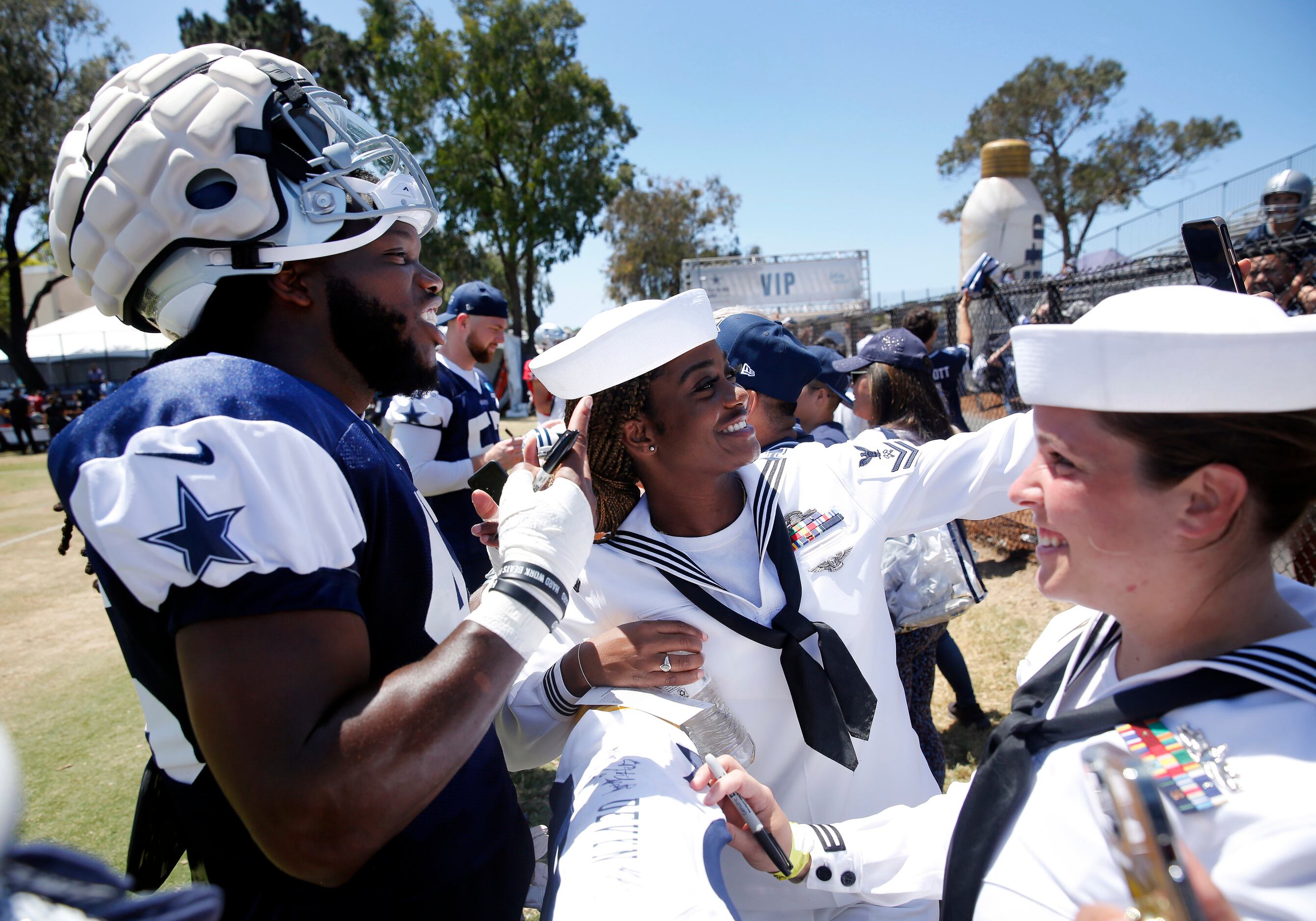 Navy logistics specialists Janisha Stout takes a photo with Dallas Cowboys rookie linebacker...