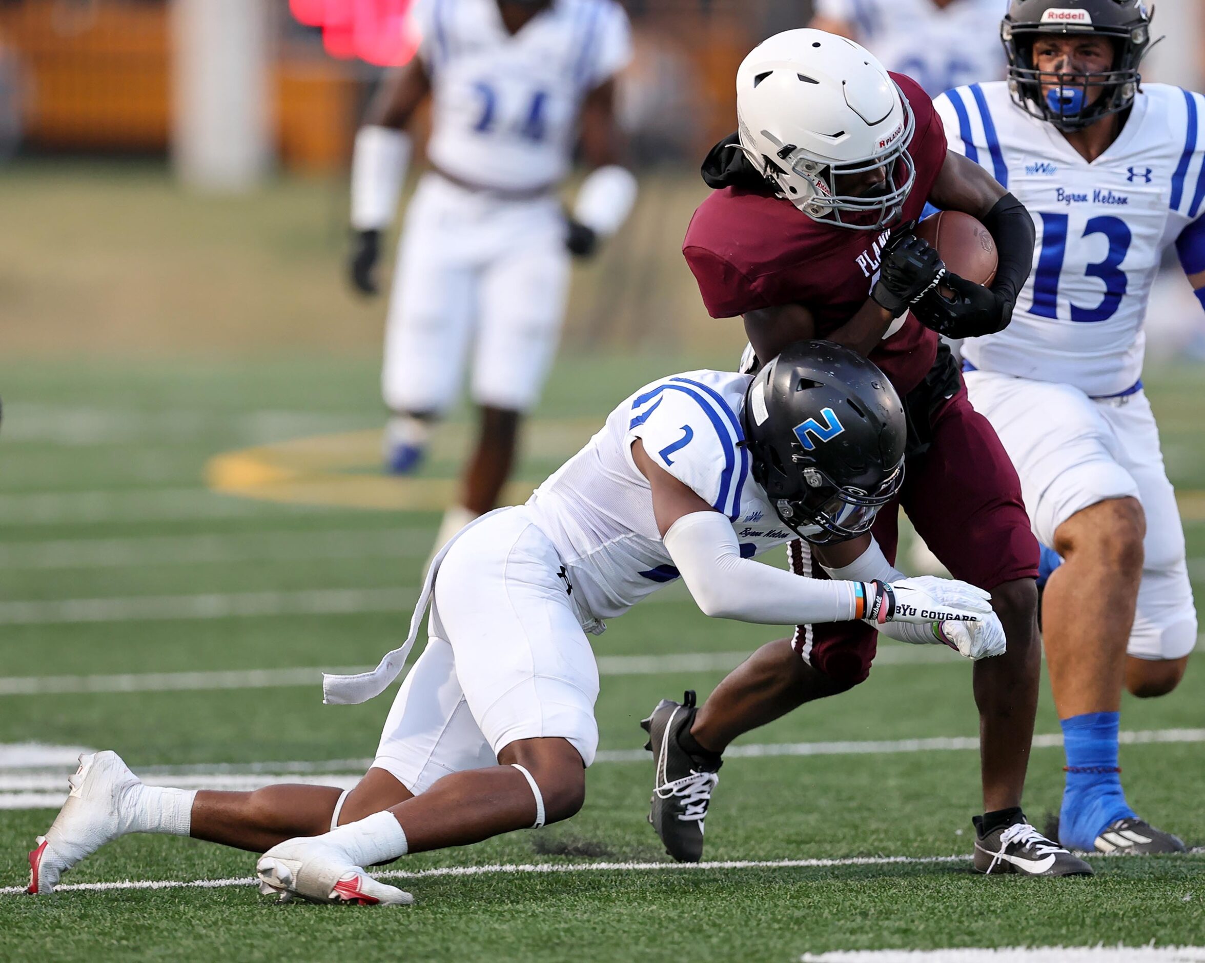 Plano wide receiver DJ Hamilton fights his way for yardage against Byron Nelson cornerback...