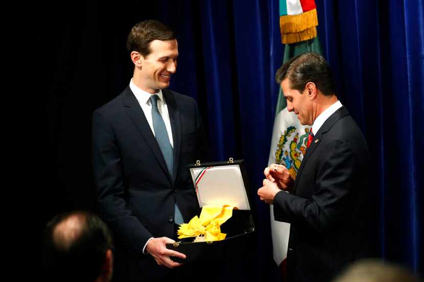 El presidente mexicano Enrique Peña Neto, a la derecha, entrega al asesor principal de la...