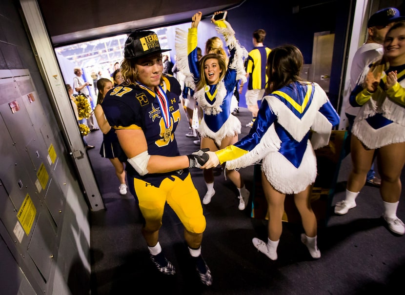 Highland Park defensive lineman Turner Coxe (97) gets a hand from members of the Highland...