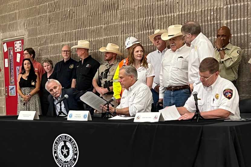 Gov. Greg Abbott, flanked by Somervell County Judge Danny Chambers (left) and Texas Division...